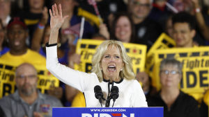 Jill Biden, Joe Bidens fru, talar inför sin mans supportrar. Jill Biden sträcker upp handen när hon står i en talarstol och pratar till Joe Biden anhängare.