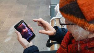 En av de yngre flickorna, Finland, är född i vårt land. Desiré tittar på bilder från telefon