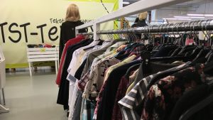 Långtidsarbetslösa kan sysselsättas på föreningens återvinningscentral för textilier. Kläder hänger på en klädstång i återvinningscentral.