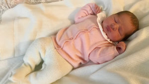 Nyfödd sovande prinsessa. Sovande baby i rosa kofta