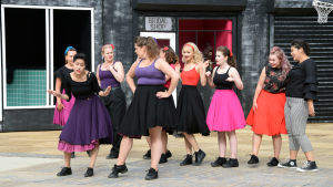 West Side Story på Raseborgs sommarteater 2018. Nio kvinnor på en utescen iklädda femtiotalsklänningar.