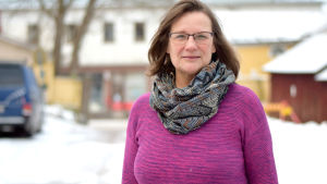 Vi lämnar ingen ensam i den här situationen, säger Hangös grundtrygghetsdirektör Elisabeth Kajander. kvinna i fuccsiaröd tröja utomhus