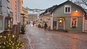 Paraplyer är en vanlig syn i Borgå trots att det är december. Julljus och regn på Mellangatan i Borgå.