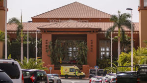 Hotellet H10 Costa Adeje Palace på Teneriffa har satts i karantän på grund av coronaviruset. En stor orange byggnad som blivit avspärrad av polisband. Framför byggnaden står en polisbil och en ambulans parkerade.
