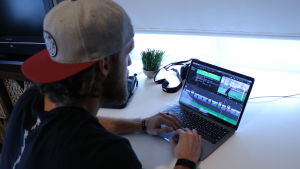 Matt Poland håller sig sysselsatt med att filma och klippa videon. En man med keps på huvudet sitter framför en dator.
