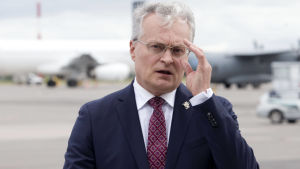 Gitanas Nauseda Gitanas Nauseda står på en flygplats med flygplan i bakgrunden.