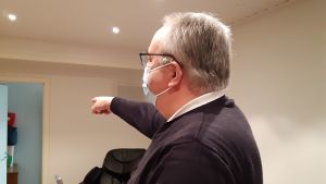 Kenneth Lindvall ordförande i VaLaSu Valtakunnallinen Lastensuojelu ry Kenneth Lindvall med corona-munskydd pekar mot en öppen dörr