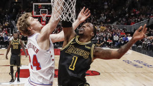 Lauri Markkanen till vänster. Lauri Markkanen och Kentavious Caldwell-Pope i närkamp under korgen.