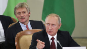 Dimitry Peskov är en av president Vladimir Putins närmaste medarbetare. Putins talesman Dmitrij Pdeskov strax bakom president Putin under en konferens i Sotji den 11 oktober 2017.