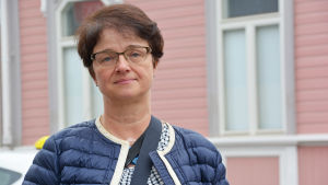 Teamledare Gunilla Träskelin är glad över att studerandena kan studera på plats. Kvinna står framför ett rosa stenhus.