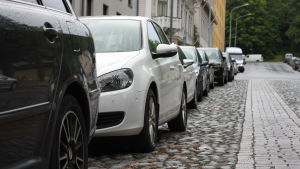 Det är viktigt att man håller koll på mötande trafik, cyklar och fotgängare då man svänger över till motsatt körfält. En rad av parkerade bilar längs en gata.