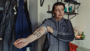 Carolina Sinisalo visar en tatuering på armen där Robins namn, födelse- och dödsdatum är tatuerade.