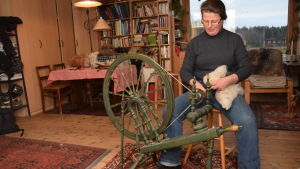 Rannvi Wallen glider nästan in i trans när hon använder spinnrocken, det är så rogivande. Rannvi Wallen sitter vid en spinnrock och spinner.
