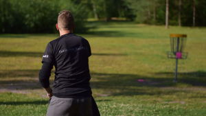 På sista delen av banan används en putter. Joni Lipponen kastar frisbeen i korgen. Frisbeegolfaren Joni Lipponen kastar en putter i korgen.