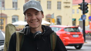 Juuso Hämäläinen tycker om de nya cyklarna. Man står och ler med en gitarrväska på axeln.