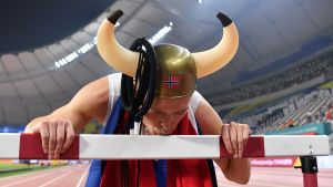 Karsten Warholm – en äkta häckviking. Karsten Warholm kysser en häck iklädd vikingahjälm.