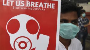 "Låt oss andas. Sluta förgifta luften i New Delhi" står det på den här skylten som bärs av en man med andningsskydd i New Delhi 3.11.2019 "Låt oss andas. Sluta förgifta luften i New Delhi"står det på skylten som bärs av en man med andningsskydd i New Delhi 3.11.2019