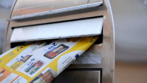 Tidiningsutdelarnas lön sjönk en hel del när de flyttades från Posten till Posti Palvelut. Tidning sticker ut från postlåda