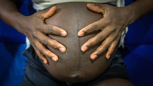 Graviditet och förlossning kan bidra till döden bland flickor. En gravid kvinnas mage syns på bild. Kvinnan håller i sin mage.