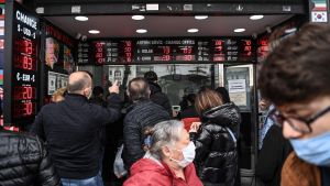 Kunder vid ett valutakontor i Istanbul den 22 mars. Den turkiska liran förlorade som mest 17 procent mot dollarn på måndagen efter beskedet att Erdogan hade sparkat Agbal. Kunder står och tittar på skärmar på ett valutakontor.