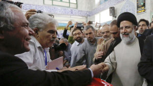 Presidentkandidaten Ebrahim Raisi (i svart turban) hälsar på valfunktionärer i en vallokal i Teheran. 19.5.2017