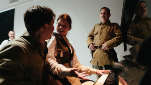 En förslagen förförerska? Roosa Söderholm som Harriet Thesleff, flankerad av Pyry Nikkilä som Lagus och Robin Svartström som Gadolin. I bakgrunden Santtu Karvonen. Foto från Harriet på Ryhmäteatteri.