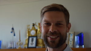 Turismchefen Jon Lindström i Hangö. En glad man i skägg tittar in i kameran.