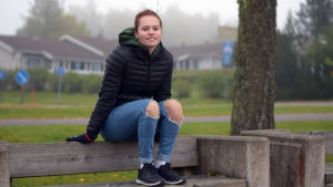 Sjundeåbon Alexandra Broman studerar nu vid gymnasiet i Kyrkslätt och därefter blir det säkert fortsatta studier och flytt hemifrån. Men hon kan gott tänka sig att bo i Sjundeå igen när det är dags att bilda familj. n ung kvinna, tonåring, med rött hår i fläta bak och svart jacka. Sitter på ryggstödet på en parkbänk. Ser rakt in i kameran.