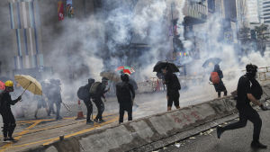 Demonstranter drabbade samman med kravallpolis på flera olika håll i Hongkong på Kinas 70 självständighetsdag Demonstranter med paraplyn i en tårgasdimma, Hongkong den första oktober 2019.