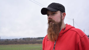 Kristoffer Nilsson prövade på höstvete för första gången. Hittills har det gått bra. man i röd munjacka och skägg på åker