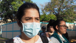 Från kris till kris: Under protesterna mot Daniel Ortega 2018 bar många demonstranter ansiktsmask för att skydda sin identitet mot förtryckapparaten. Nu bär de mask för att skydda sig mot coronasmitta. Kvinna ser förbi kameran. Hon bär munskydd.