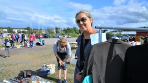 Mia Roos säljer för första gången på västra åstrandens loppmarknad. En kvinna vid sitt stånd.