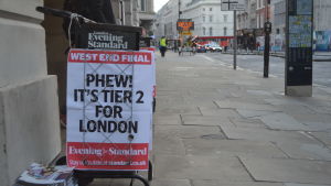 Efter den andra nedstängningen får olika regioner öppna upp i december beroende på smittläget. I London får bland annat pubar som serverar mat öppna. Bild på skylt med text på engelska och tidningar på hög på trattoaren.