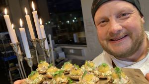 Micke Björklund visar upp årets självständighetssnacks. Kocken Micke Björklund visar upp årets självständighetssnacks 2020, forelltartar på rågknappar.