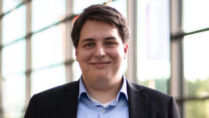Kujala ställer själv upp i valet i Esbo för SFP, och påverkas i stor grad av den ändrade tidpunkten. En man med svart kostym och blå skjorta ser in i kameran. Han är fotad inomhus, i bakrgunden stora fönster genom vilka grönt syns.
