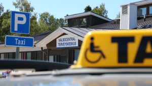I stan kan man ringa efter en ny taxi, men i glesbygd fungerar det inte. Ingången till HVC i Närpes. I förgrunden skymtar en gul taxiskylt.