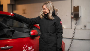 Johanna Nyberg och hennes kolleger har en gemensam arbetsbil. Den har inte används för samåkning - inte i alla fall inom ramarna för stadens samåknigspilot. En kvinna står brevid en röd bil. Hon ser på bilen och har sin arm på dess tak. Bilen och kvinnan står i ett parkeringsgarage.
