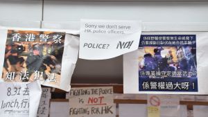 På demokrativäggen finns det också budskap som stöder polisen. Att slåss mot polisen är inte att kämpa för Hongkong, står det på en affisch. Affischer på en vägg.