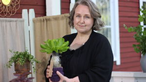 Maria Ståhl - en stolt och erfaren hydroponisk odlare En kvinna håller upp en glasflaska med sallad i.