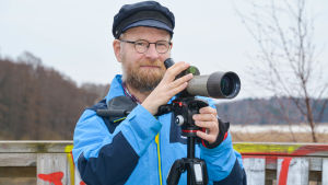 Pontus Rancken passar på att kika på fåglar under dagtid, när andra jobbar En man med sin fågelkikare.