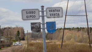 Den här skylten har markerat kommungränsen ganska länge. Länge har också diskussionen om Myras framtid gått het. En sliten skylt där det står Sibbo och Vanda samt flagnad bild av kommunvapen.
