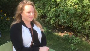 Menna Hedberg är stödperson för Helsingfors mission. Menna Hedberg sitter på en bänk