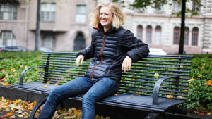 Ibland är Lisa Gerkman så här glad, men hon kan också bli väldigt arg. Lisa Gerkman ler mot kameran medan hon sitter på en bänk.