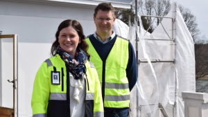 Mikaela Pappila och Mikael Jensen är nöjda med att renoveringsarbetet är i gång på allvar. Mikaela Pappila och Mikael Jensen står på taket till ena flygeln på Amos Anderssons sommarresidens. Båda har vita hjälmar på huvudet och gula västar.