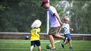 Pontus Bäcklund flaggade för Finland. Johanna Bäcklunds barn Alfons och Vilhelm leker med pappan Pontus.