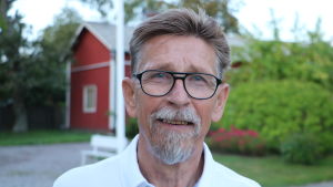 Carl-Gustav Mangs säger att Kaskö ansökt förut, med rätt klent resultat. En man med glasögon står på en gård. I bakgrunden skymtar ett rött hus.