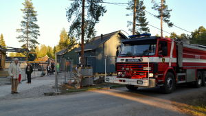 Ett tiotal brandmän besökte Lappträskhusen för att bekanta sig med dem. En branbil kör förbi nybyggda hus