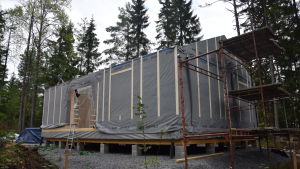 Elementen i halmhuset är tillverkade i fabrik i Litauen innan de kommer till byggbolagets hall i Billnäs. Ett elementhus utvändigt som är nästan klart, bara taket fattas