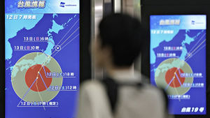 En tågpassagerare på Shinjuku-tågstationen i Tokyo tittar på en väderprognos som visar tyfonen Hagibis rörelser. Bilden är tagen lördagen den 12 oktober 2019 En tågpassagerare tittar på en väderprognos som visar tyfonen Hagibis rörelser på Shinjuku-tågstationen i Tokyo lördagen den 12 oktober.