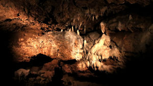 Valaistuja, pitkulaisia kivimuodostelmia luolassa, eli stalaktiitteja ja stalagmiitteja.